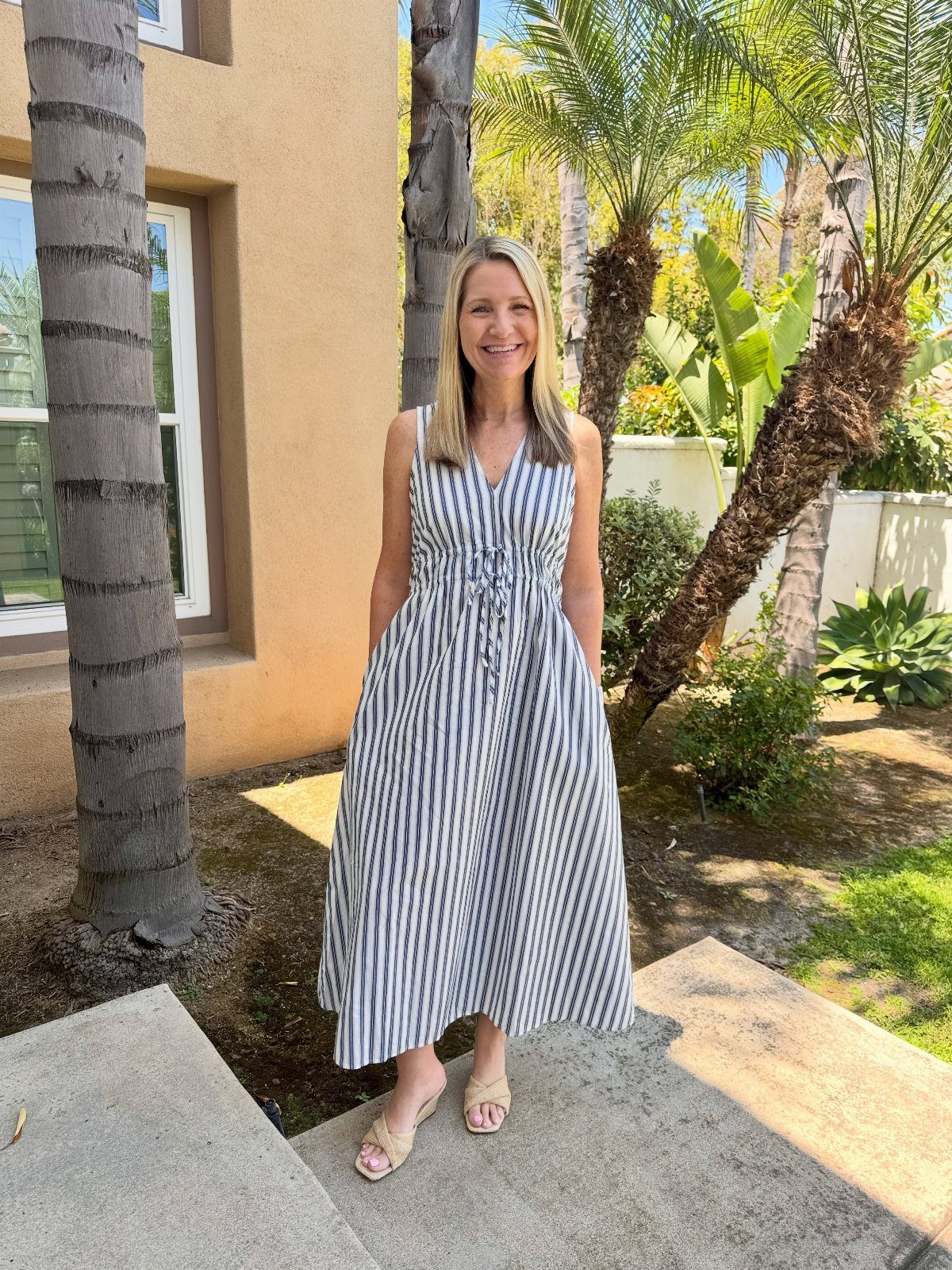 4th of July Outfits: 8 Festive Looks for Women 3 Woman wearing a blue and white striped maxi dress standing outdoors by palm trees