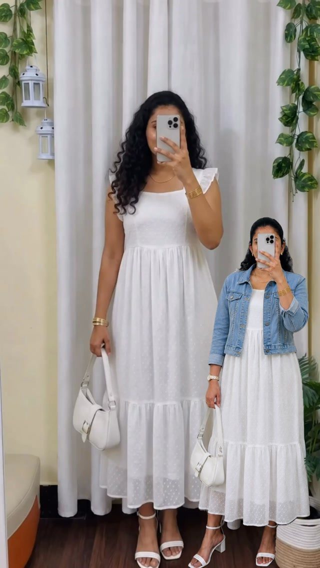 Two women wearing white midi dresses, one with a blue denim jacket.