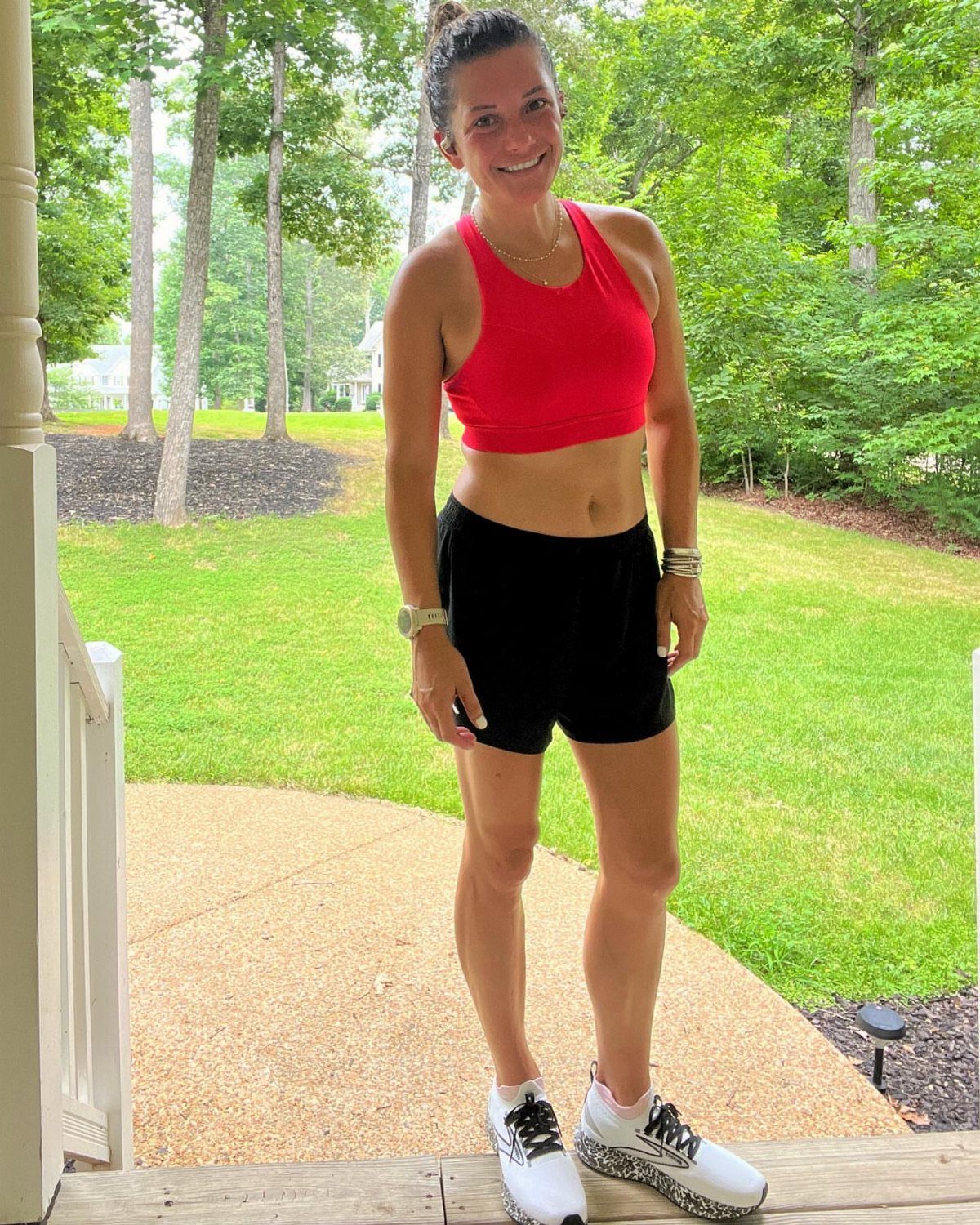 Woman wearing a red sports bra and black athletic shorts for running.