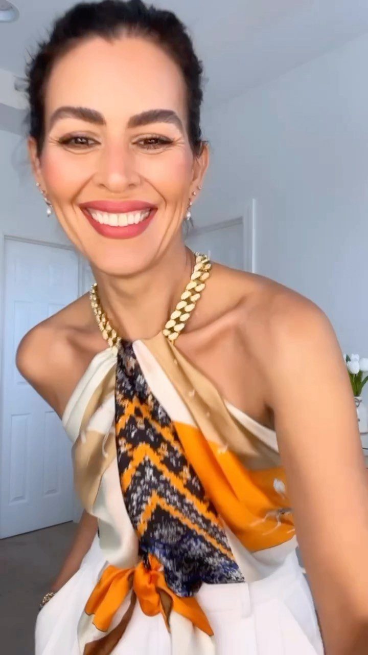 70's Inspired Outfits: 13 Retro Looks to Try Right Now 4 Woman wearing a patterned halter top and a chunky gold chain necklace.