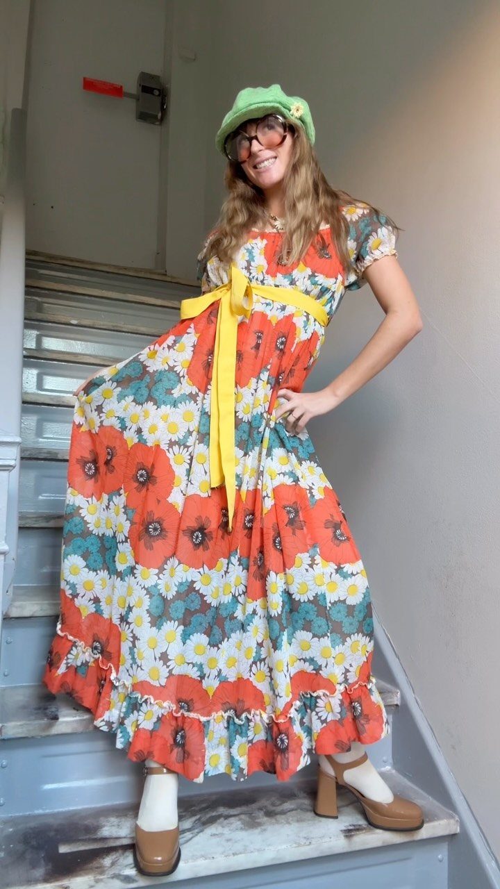 70's Inspired Outfits: 13 Retro Looks to Try Right Now 3 Woman in a floral maxi dress with a yellow belt and green hat.