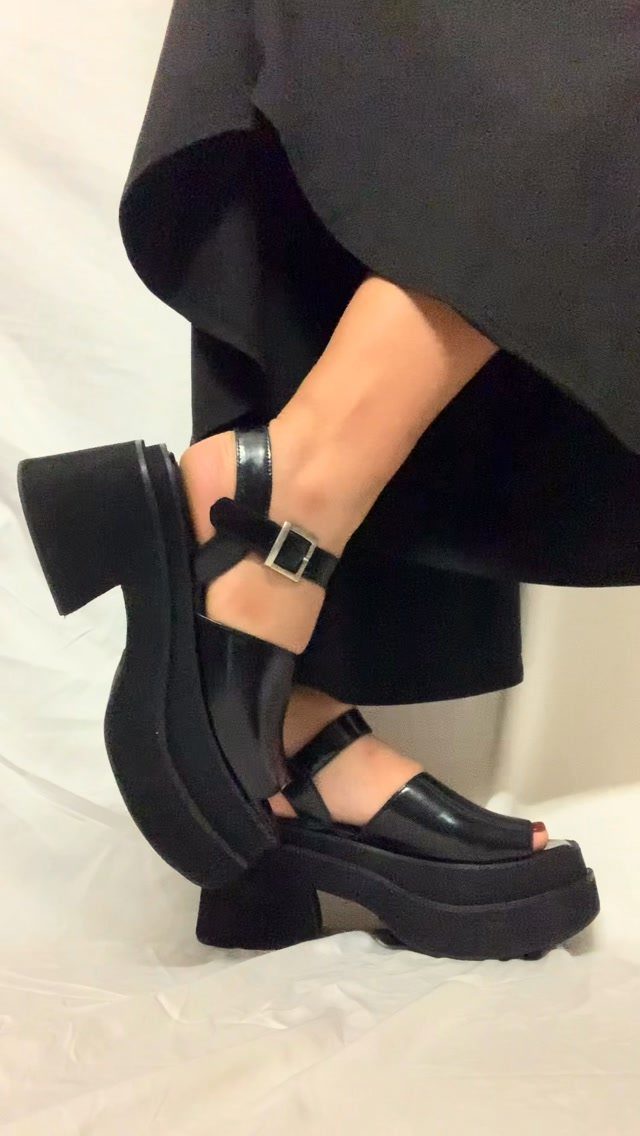 70's Inspired Outfits: 13 Retro Looks to Try Right Now 6 Black leather platform sandals with chunky heels and ankle straps on a person.