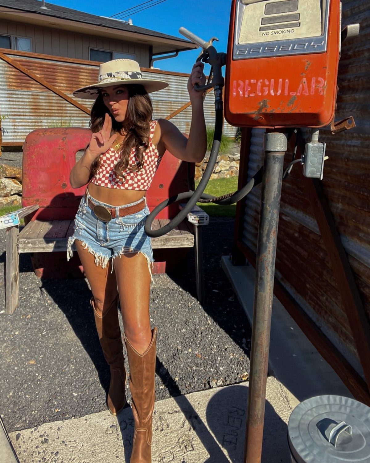 80s Inspired Outfits: 8 Bold Looks to Recreate the Decade 6 Woman in polka dot top and denim shorts wearing tall brown cowboy boots.