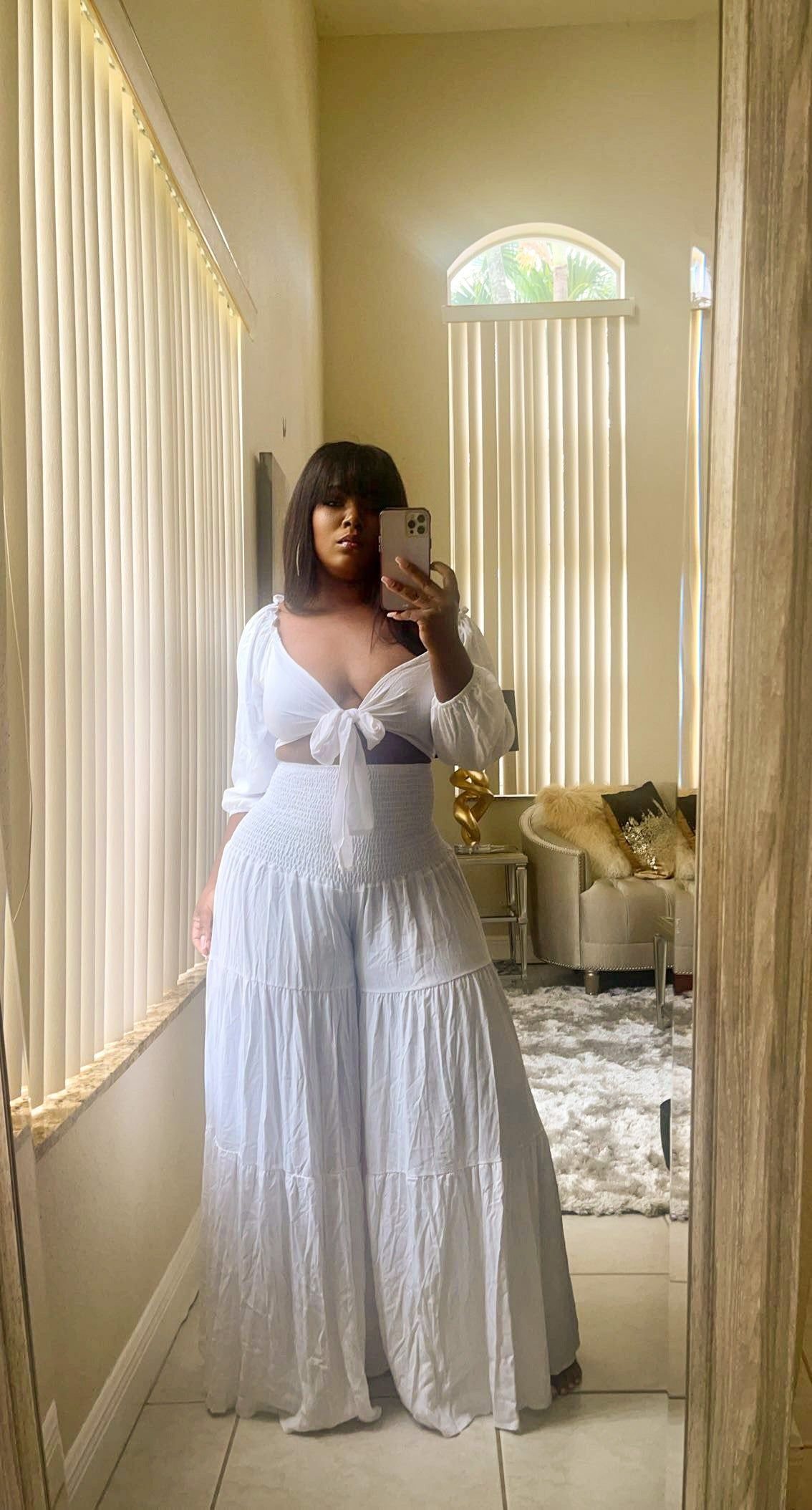 All White Party Outfits for Women: 10 Chic Ideas to Wear 3 Woman wearing a white tie-front crop top and high-waisted wide-leg white trousers.