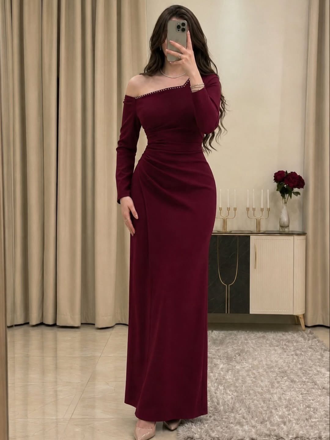 Apple Body Shape Outfits That Flatter Your Figure (9 Ideas) 5 Woman in a long-sleeved burgundy floor-length dress with a fitted waist and off-the-shoulder neckline.