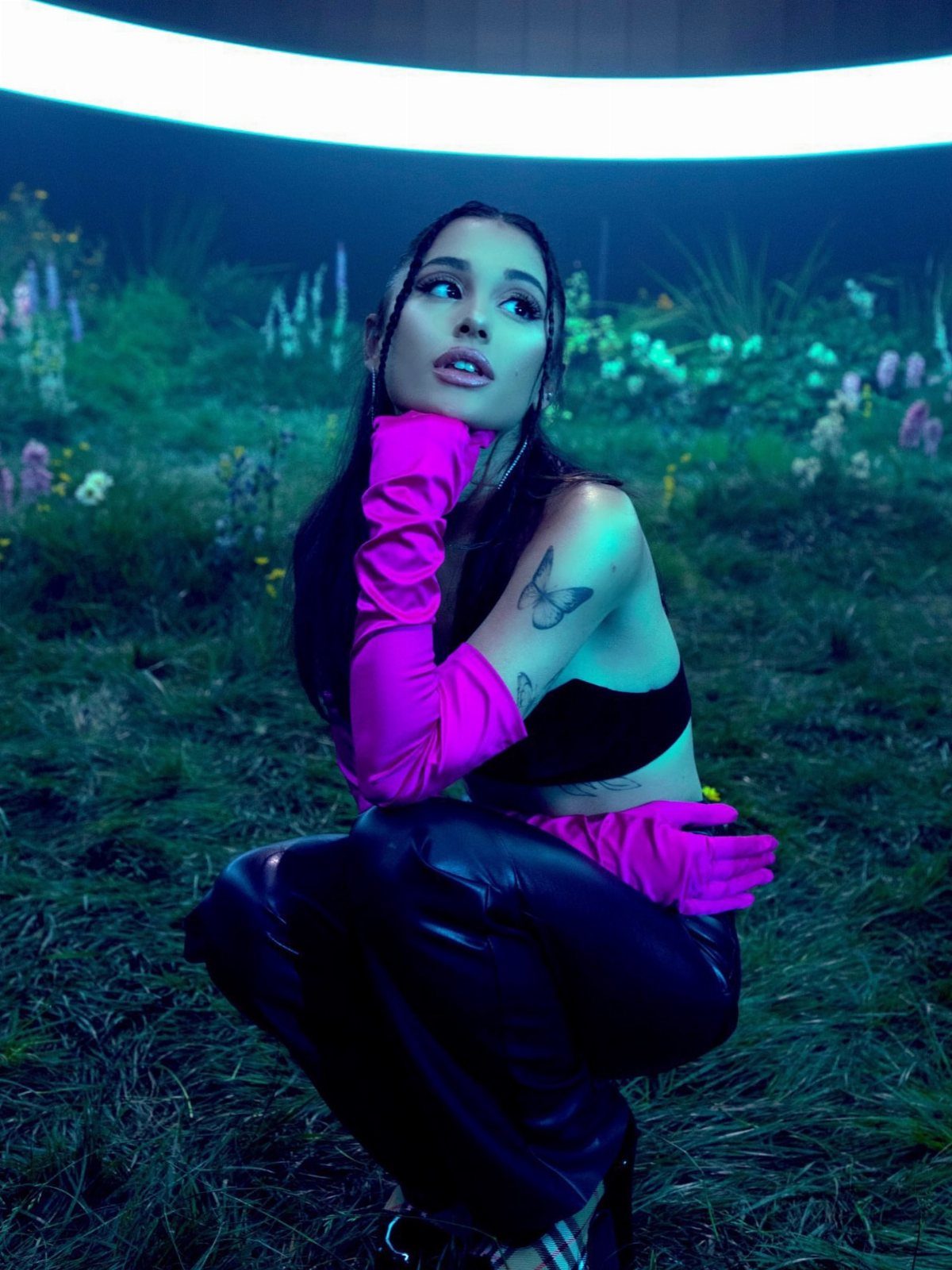Ariana Grande Concert Outfits: 12 Looks for 2026 Shows 7 Ariana Grande wearing a black crop top, leather pants, and bright pink gloves.