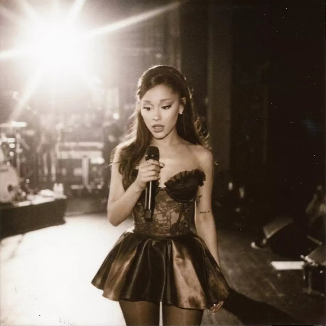 Ariana Grande Concert Outfits: 12 Looks for 2026 Shows 1 Ariana Grande wearing a strapless mini dress while performing on a lit stage.