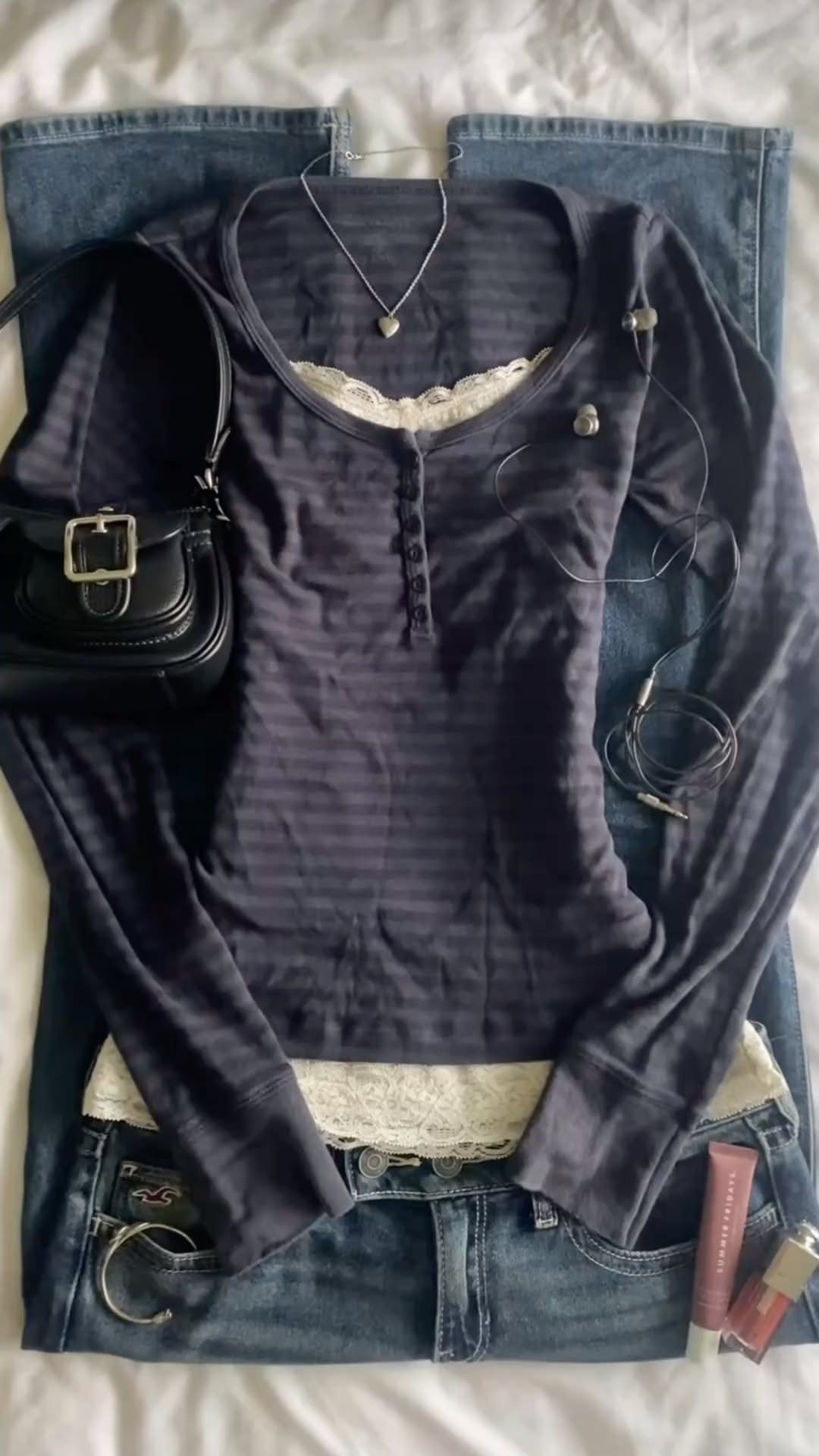 Bella Swan Outfits: 10 Iconic Looks from the Twilight Saga 7 Dark purple long-sleeved shirt and blue jeans with black handbag and accessories.