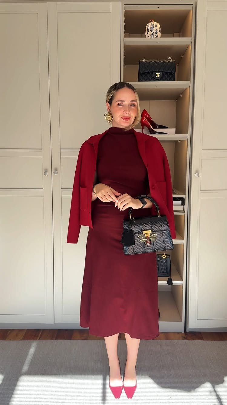 7 Burgundy Outfits for Women to Wear This Season 1 Woman wearing a burgundy midi dress and matching jacket with a black handbag.