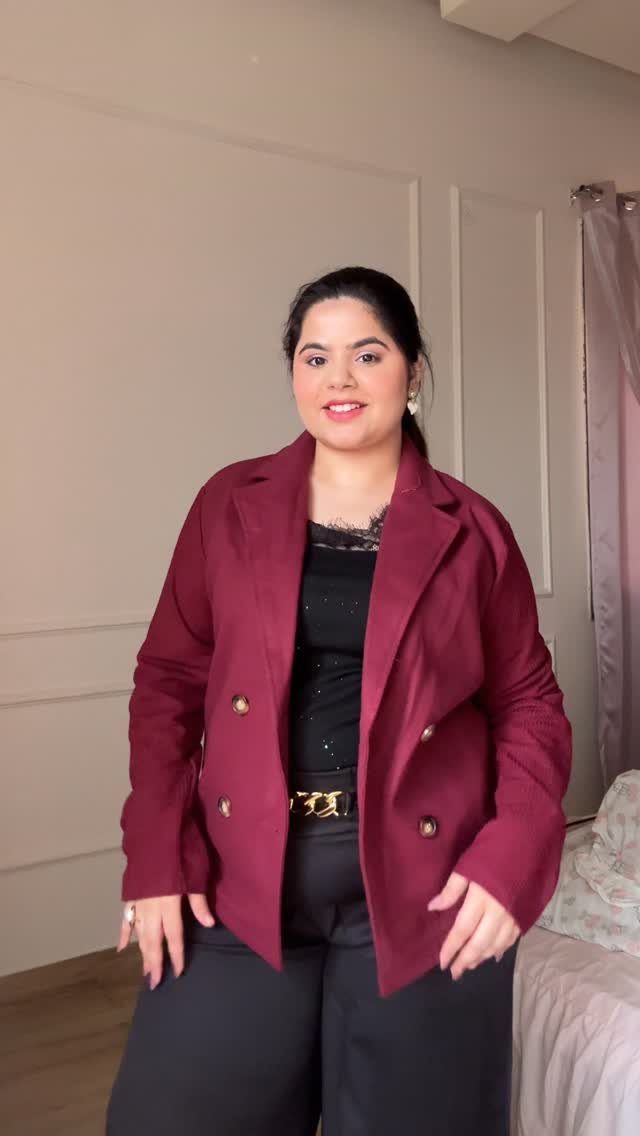 7 Burgundy Outfits for Women to Wear This Season 2 Woman wearing a burgundy blazer over a black top and black trousers.