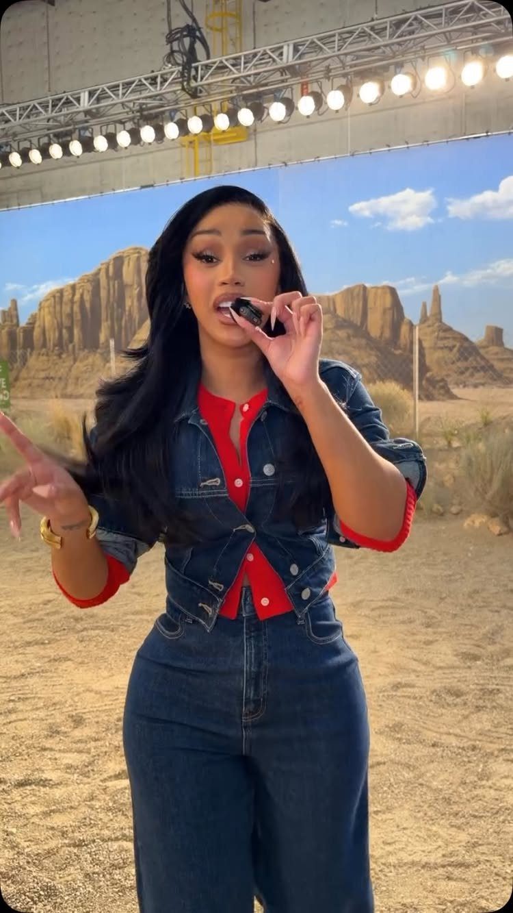 Cardi B Concert Outfits: 9 Bold Looks to Turn Heads 3 Cardi B wearing a red top, cropped denim jacket, and high-waisted blue jeans.