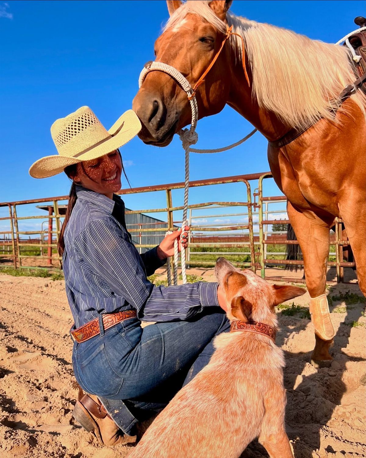 14 Coastal Cowgirl Outfits for Breezy Western Beach Style 7 Woman in cowboy hat and jeans with a horse and dog outdoors.