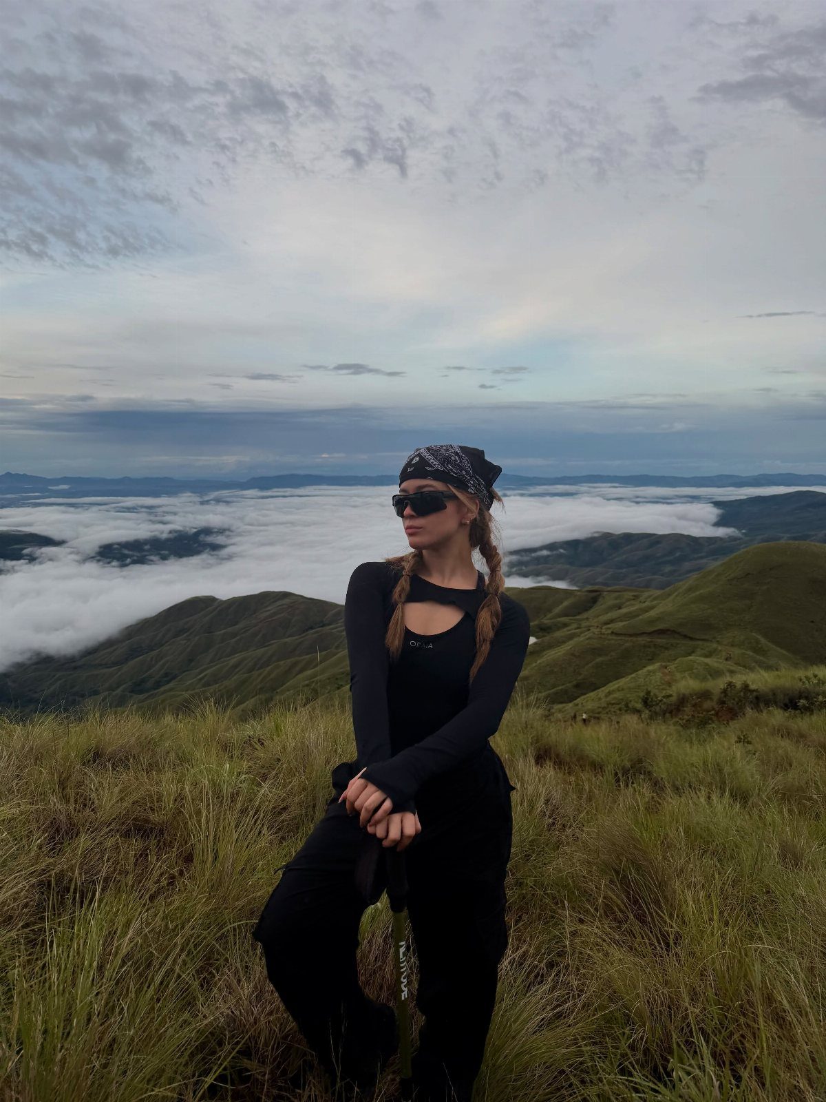 Costa Rica Outfits: 10 Ideas for Your Trip 5 Woman in black outdoor clothing and bandana standing on a foggy mountain peak.