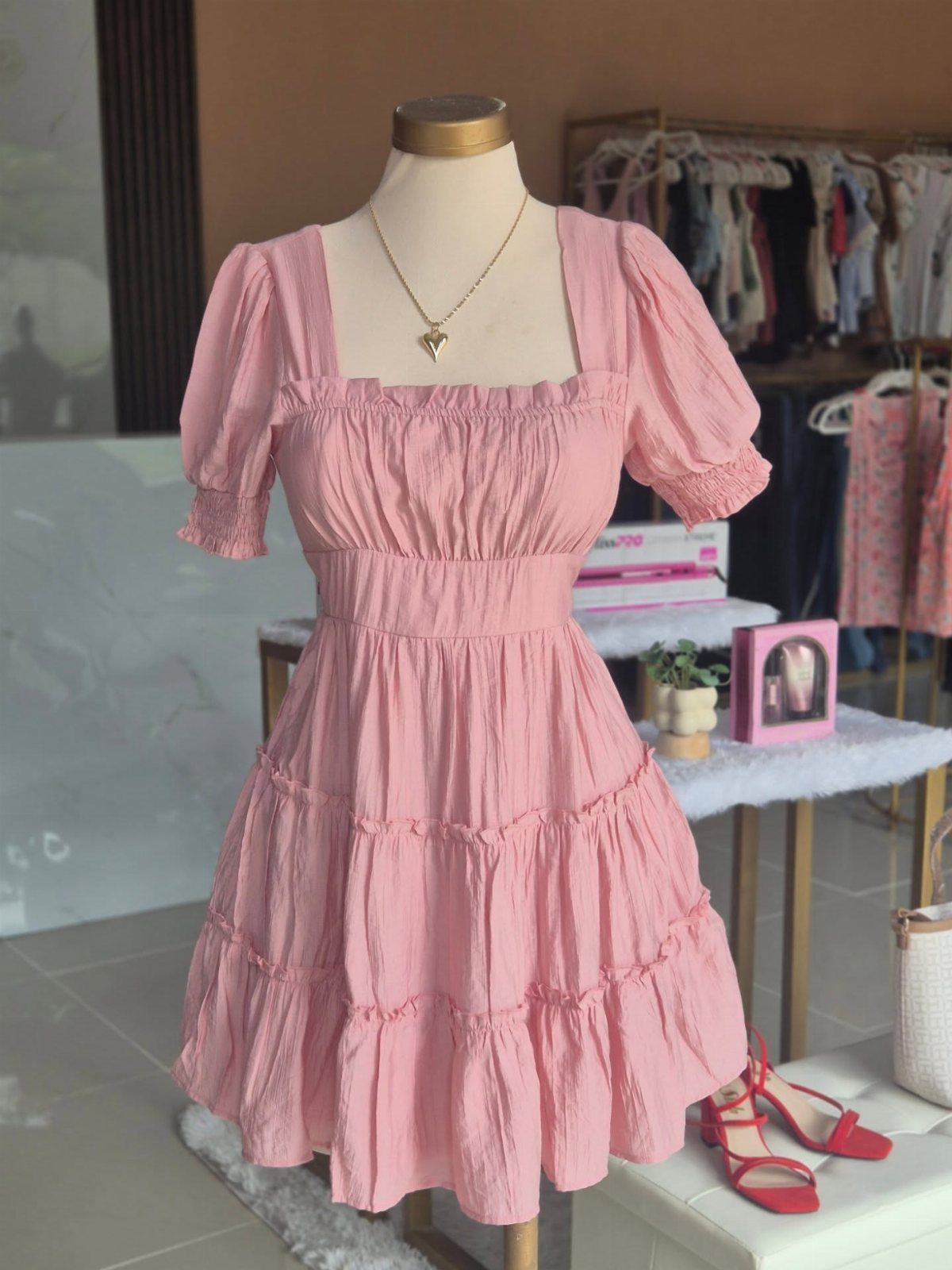 Costa Rica Outfits: 10 Ideas for Your Trip 2 Light pink tiered puff-sleeve dress on a mannequin with red strappy sandals.
