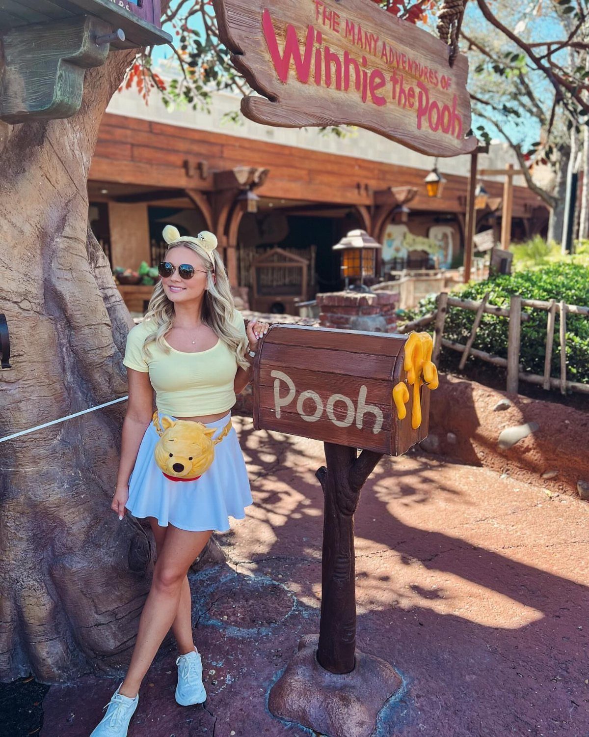 10 Cute Disney Outfits to Wear at the Parks in 2026 9 Woman in yellow top and white skirt wearing yellow ear headband at Disney