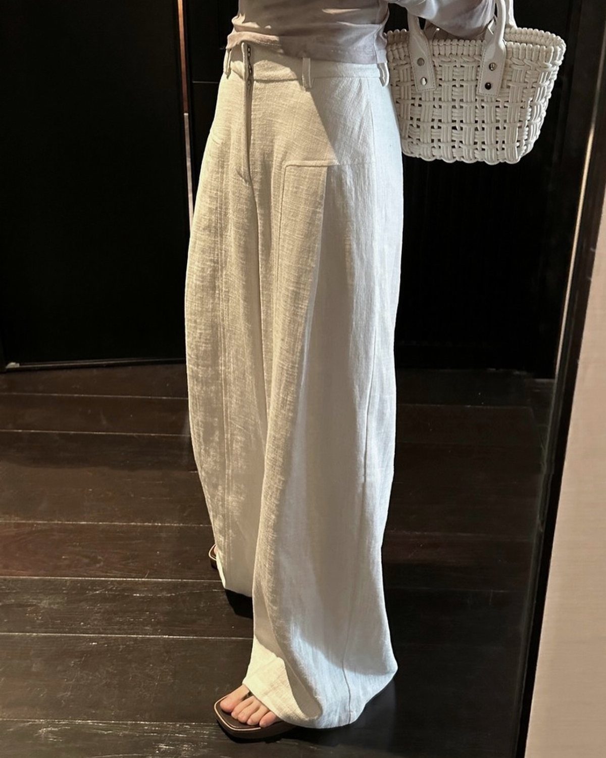 12 Cute Summer Outfits to Keep You Cool and Stylish 7 White wide-leg linen pants paired with a light top and woven handbag.