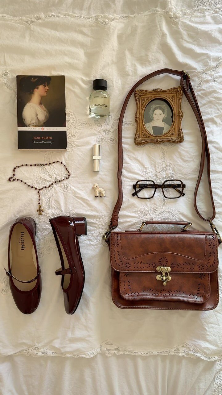 Dark Academia Outfits Female: 12 Ideas for Timeless Style 7 Brown leather satchel bag with burgundy loafers and vintage accessories on white lace.