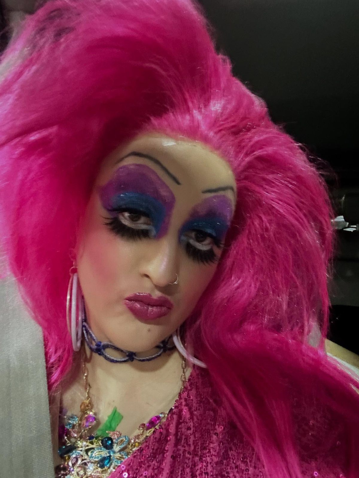 Drag Queen Outfits: 8 Bold Ideas for Your Next Performance 6 Person in drag wearing a large, bright pink wig and dramatic makeup.