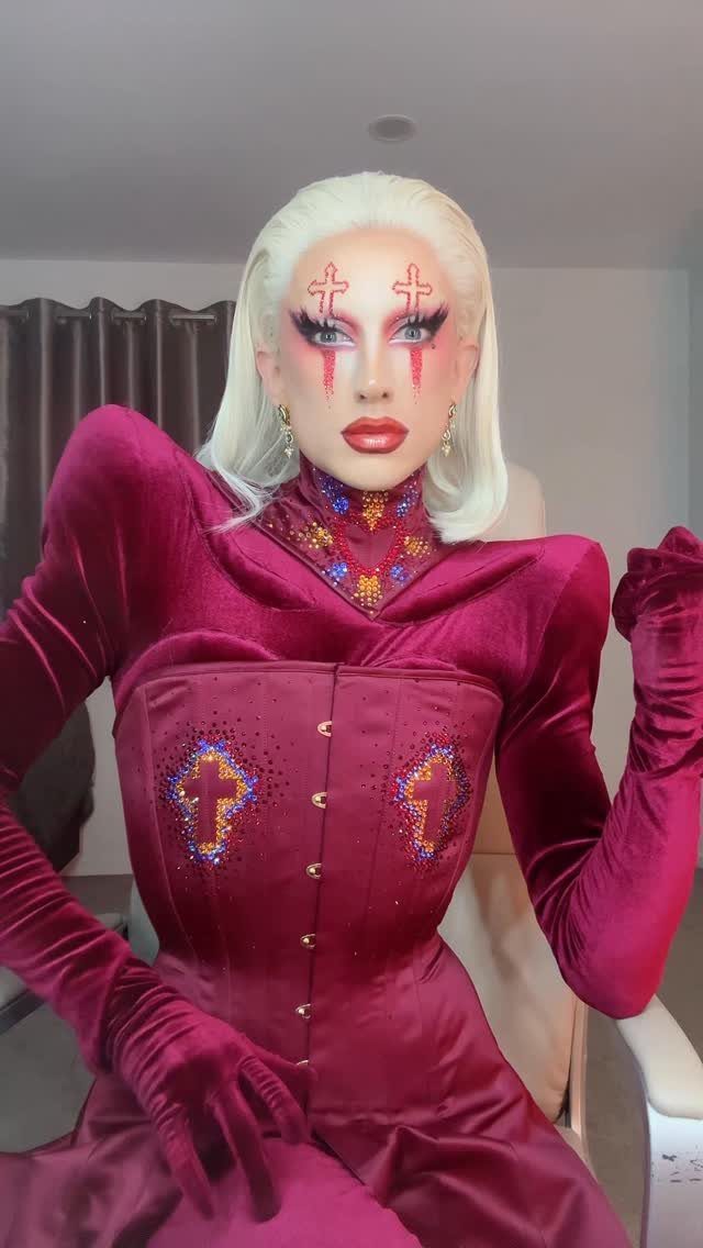 Drag Queen Outfits: 8 Bold Ideas for Your Next Performance 7 Drag queen in a maroon velvet corset outfit with dramatic red eye makeup.