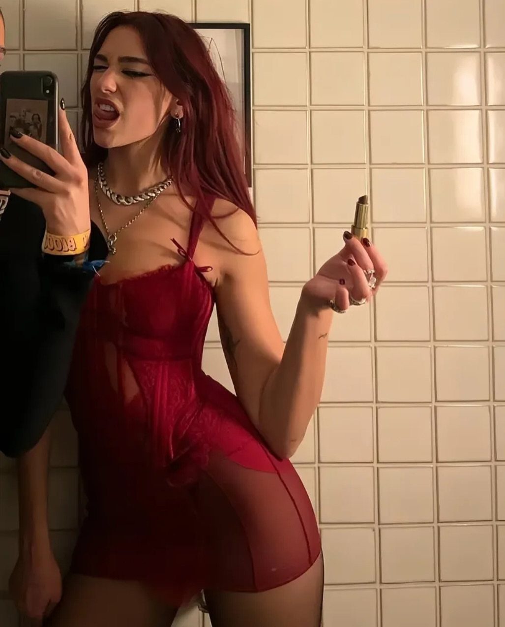 Dua Lipa Concert Outfits: 7 Show-Stopping Looks to Try 5 Woman with red hair wearing a sheer red lace mini dress and tights.