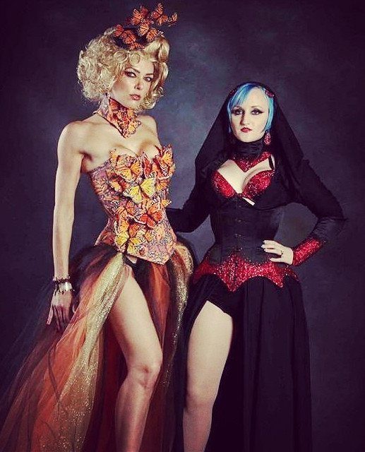 Effie Trinket Outfits: 10 Iconic Looks to Recreate 2 Two women in high-fashion costumes, one featuring a floral corset and headpiece.