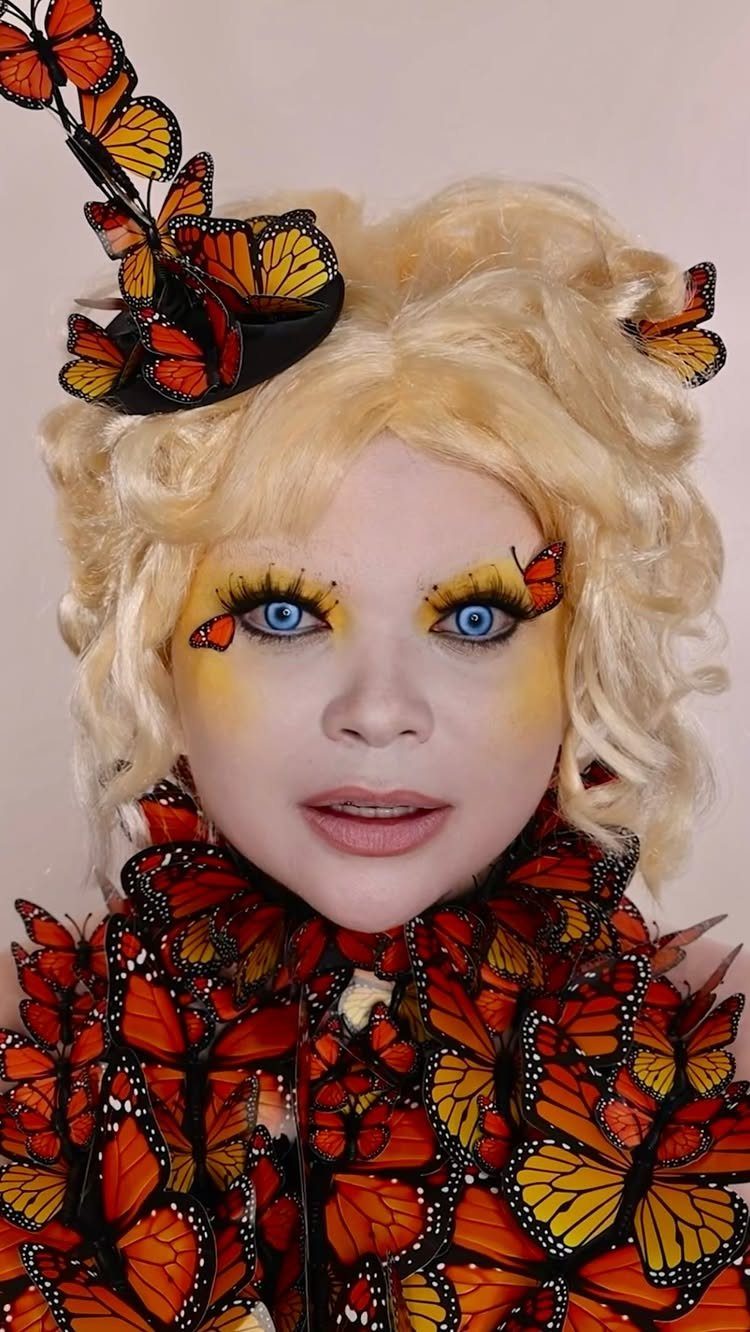 Effie Trinket Outfits: 10 Iconic Looks to Recreate 4 Person in Effie Trinket costume with blonde hair and monarch butterfly dress.