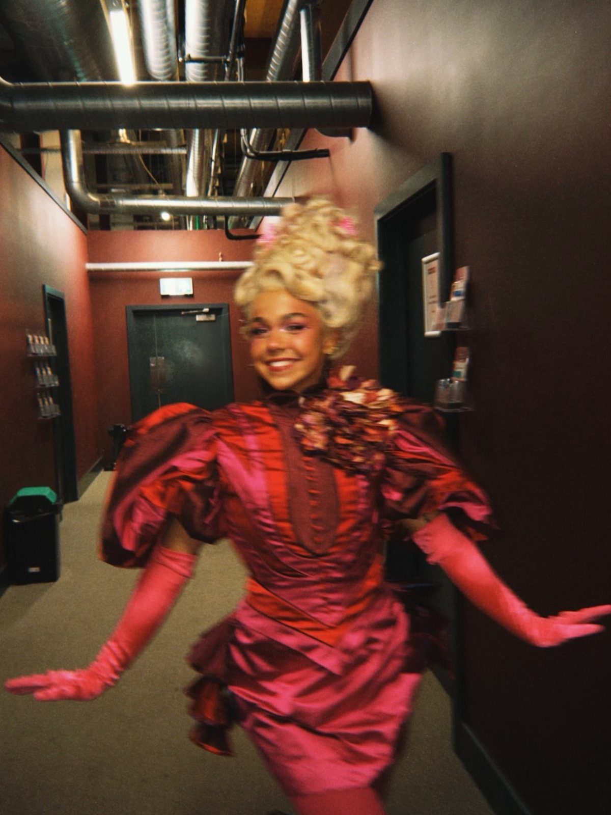 Effie Trinket Outfits: 10 Iconic Looks to Recreate 8 Person in Effie Trinket costume wearing a tall blonde styled wig and dress.