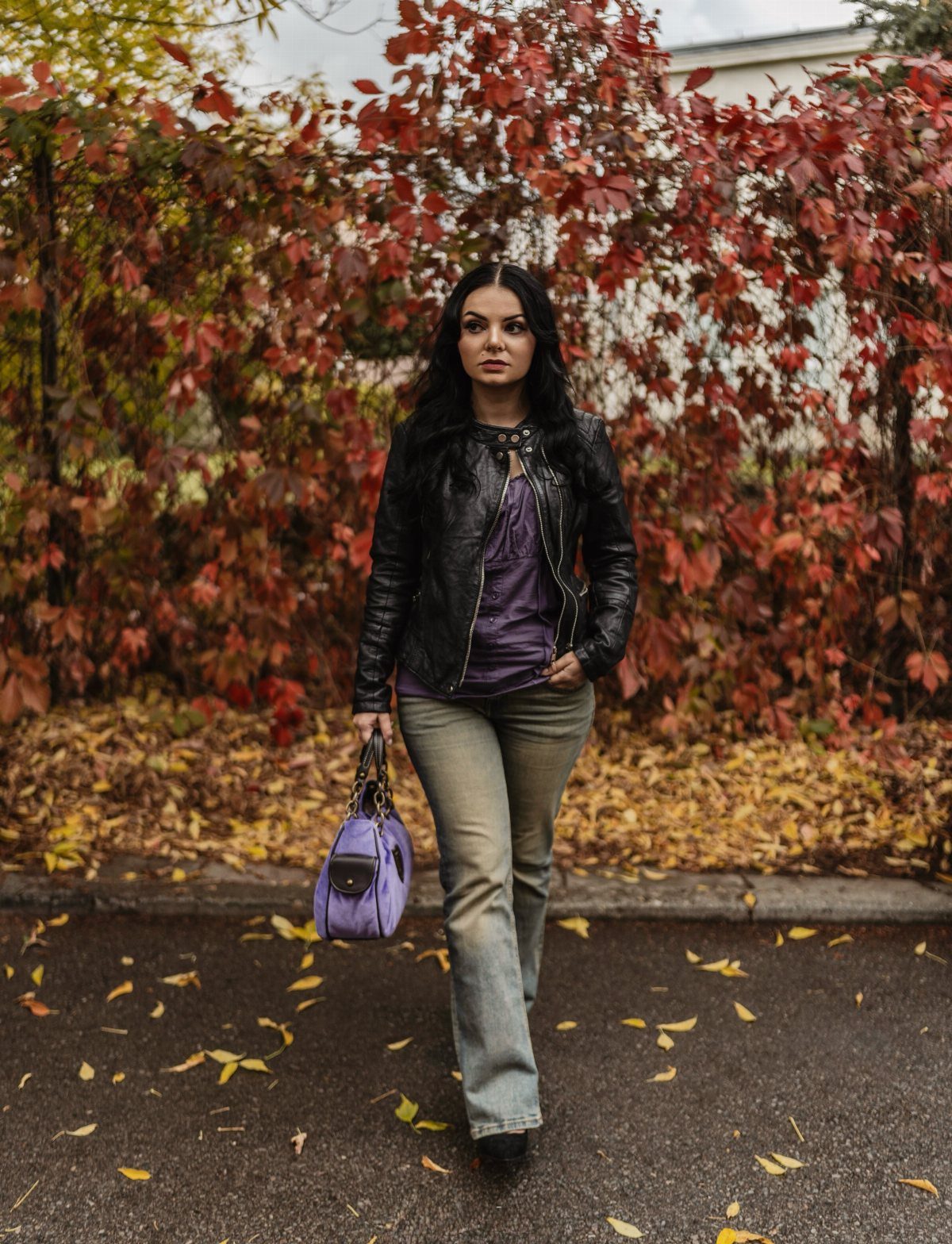 14 Elena Gilbert Outfits: Her Best Looks from the Show 12 Woman wearing a black leather jacket, purple shirt, and flared jeans in autumn.