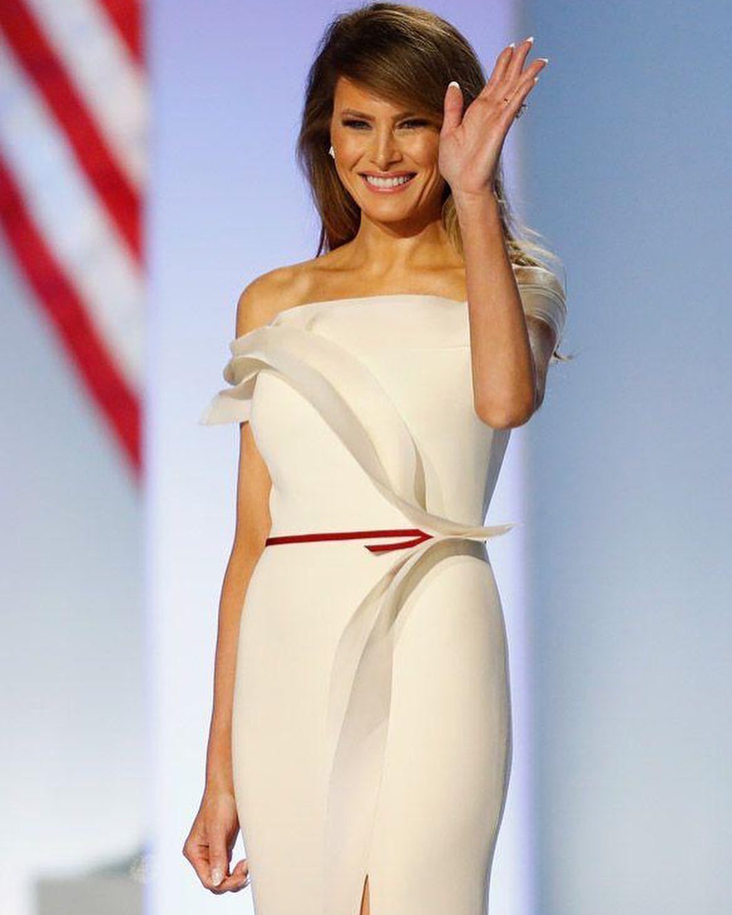 First Lady Outfits: 6 Timeless Looks to Inspire Your Style 3 Melania Trump in a white off-the-shoulder gown with a red belt waving