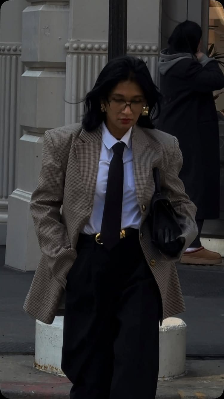 Gender Neutral Outfits: 9 Ideas Anyone Can Wear 2 Person wearing an oversized brown checkered blazer with a white shirt and black tie.