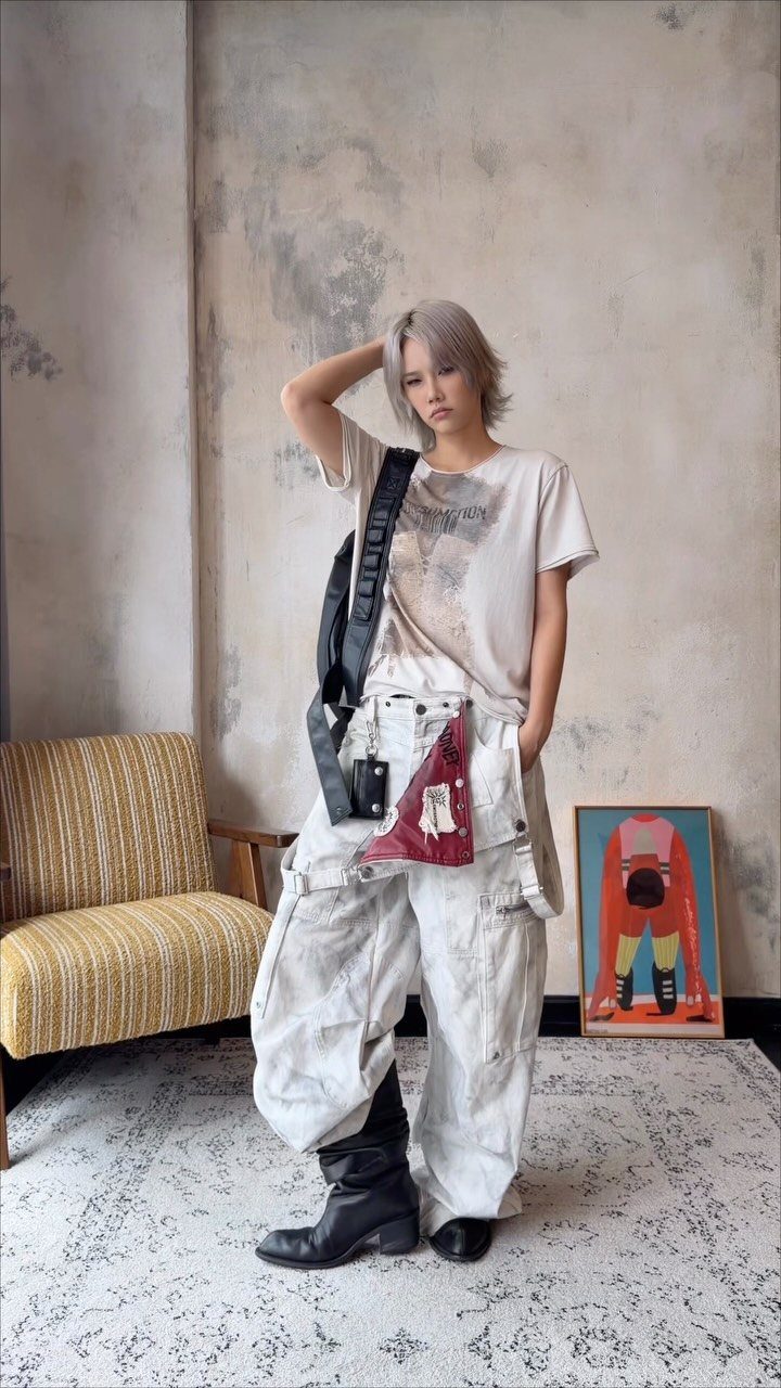 Gender Neutral Outfits: 9 Ideas Anyone Can Wear 4 Person in a graphic tee and oversized white cargo pants posing indoors.