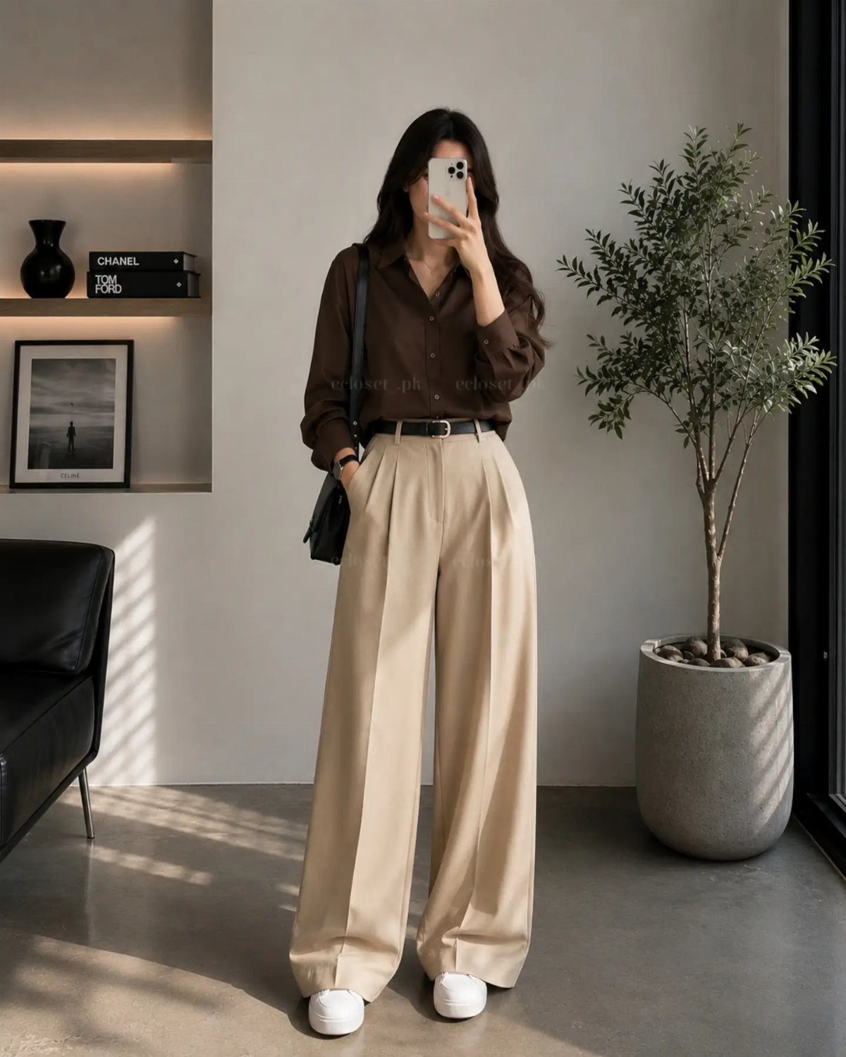 Gender Neutral Outfits: 9 Ideas Anyone Can Wear 7 Person wearing beige wide-leg trousers, a brown shirt, and white sneakers in a room.