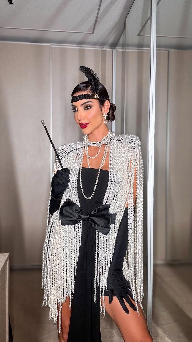 Great Gatsby Themed Outfits: 10 Ideas for Your Next Party 8 Woman in a 1920s flapper outfit with a silver beaded shawl and black dress.