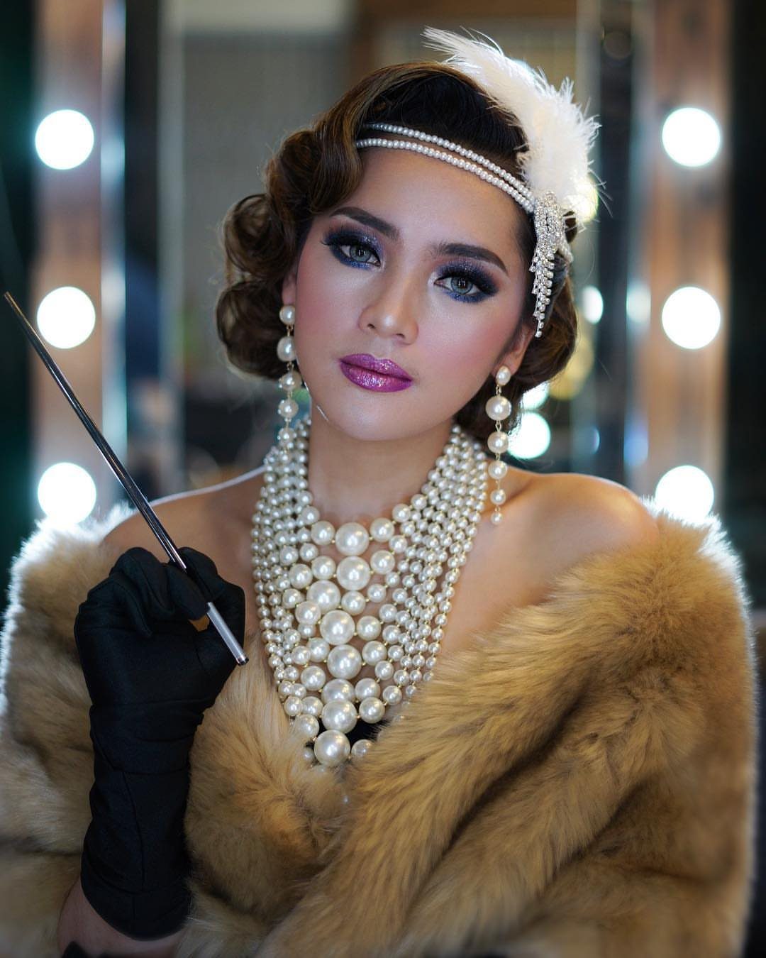 Great Gatsby Themed Outfits: 10 Ideas for Your Next Party 2 Woman in 1920s attire wearing a pearl headband, feather, and layered pearl necklaces.