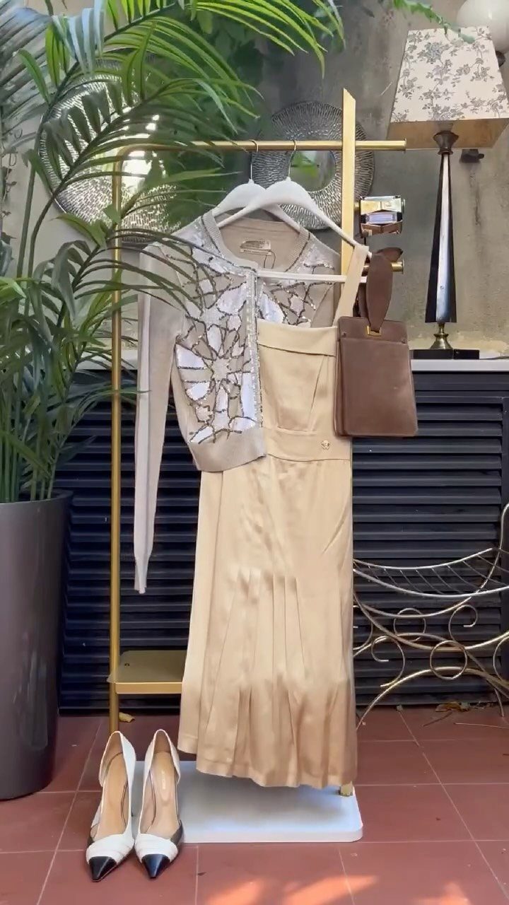 Great Gatsby Themed Outfits: 10 Ideas for Your Next Party 6 Champagne satin dress and beaded white shrug on a gold clothing rack with heels.