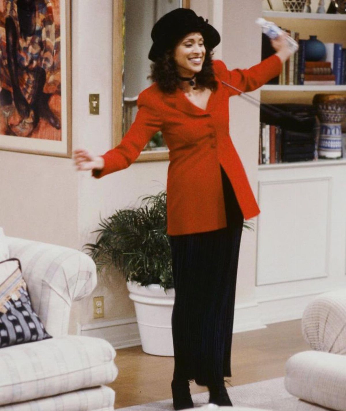 Hilary Banks Outfits: 12 Iconic Looks to Recreate Her Style 2 Woman in red blazer and black maxi skirt posing in a living room.