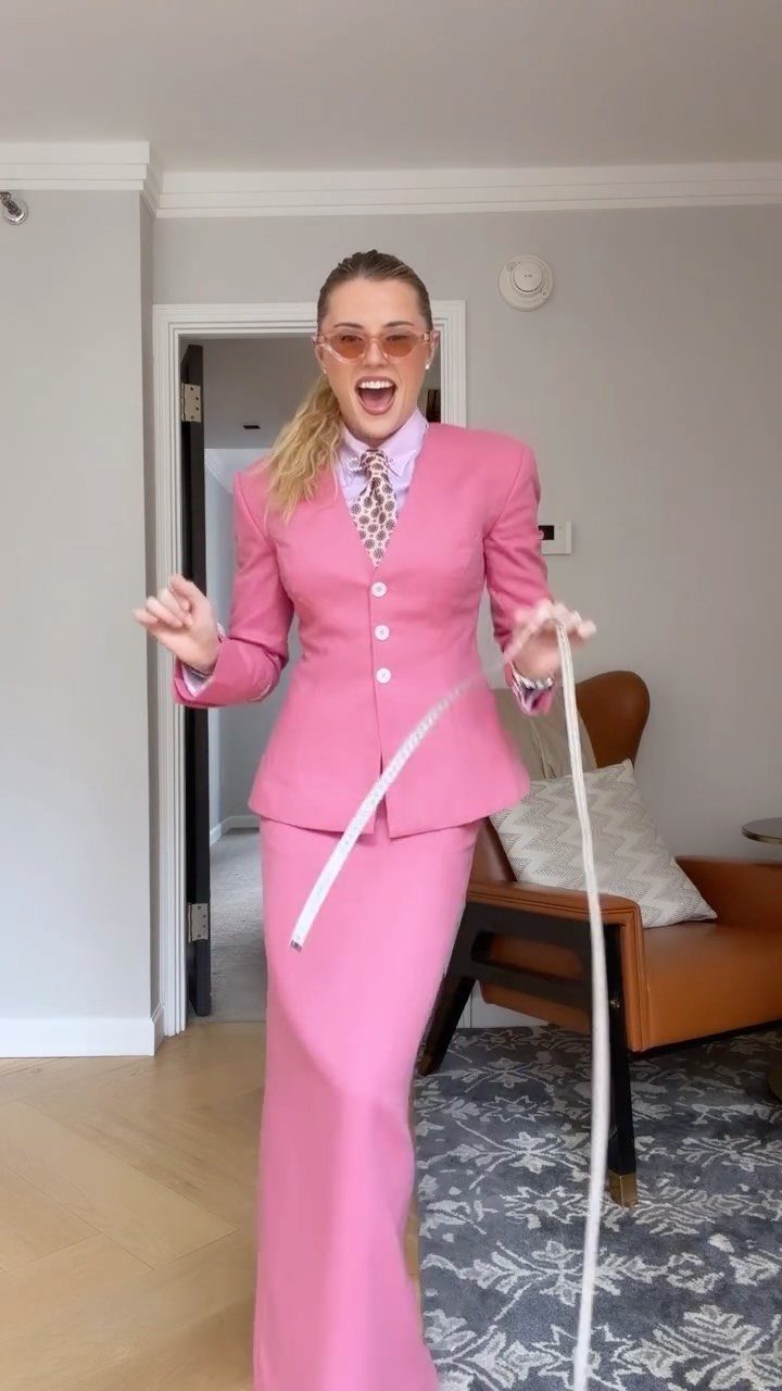 10 Legally Blonde Outfits to Channel Elle Woods in 2026 1 Woman wearing a vibrant pink power suit with a matching shirt and tie.