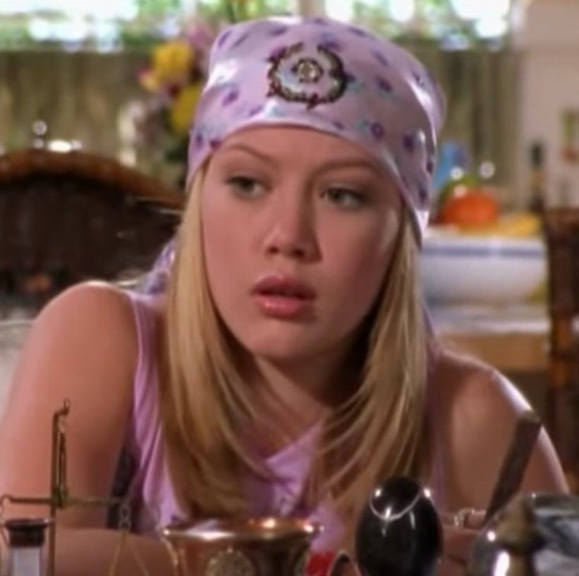 10 Lizzie McGuire Movie Outfits That Defined Y2K Fashion 10 Young woman with blonde hair wearing a purple floral patterned head bandana.