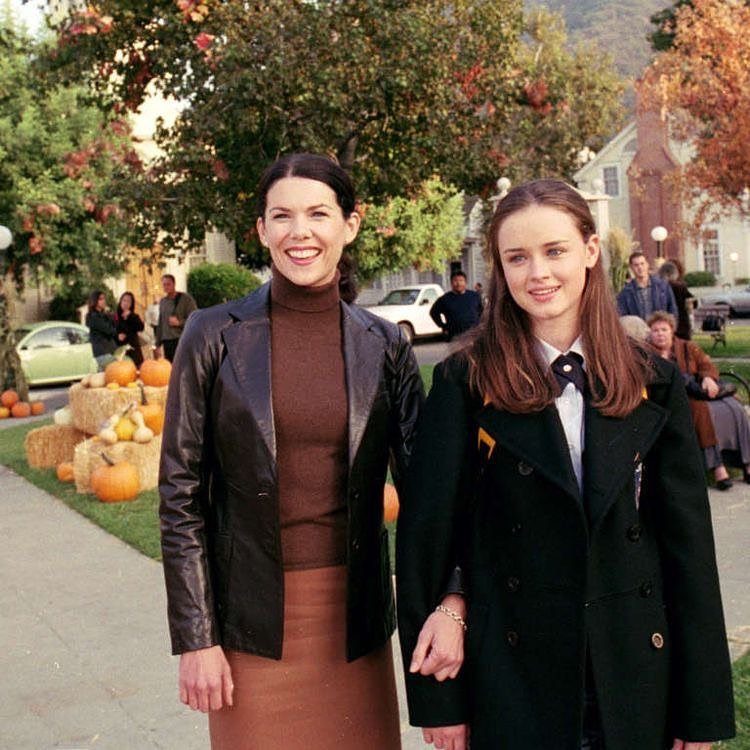 11 Lorelai Gilmore Outfits to Recreate Her Iconic Style 7 Two women posing outdoors, one in a leather blazer and one in a black peacoat.