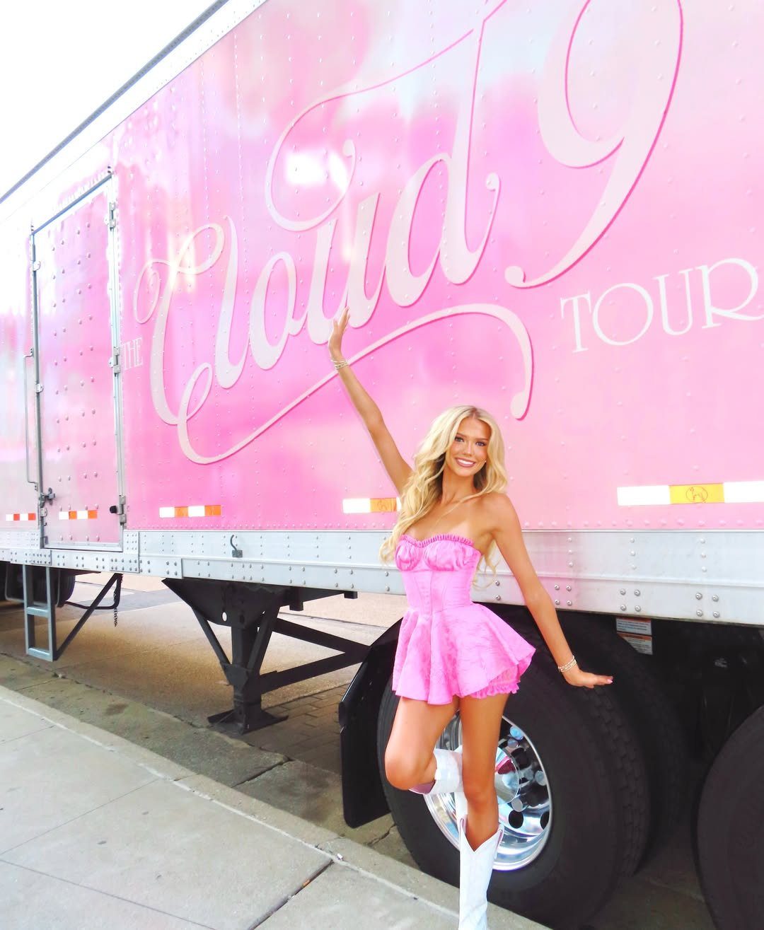 Megan Moroney Concert Outfits: 7 Ideas for Her Shows 5 Blonde woman in a short pink satin dress and white cowboy boots posing.