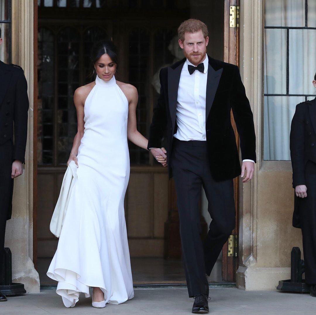 Meghan Markle Outfits: 17 Ideas from Tailored to Casual 5 Meghan Markle in a white halter-neck elegant dress walking with Prince Harry.