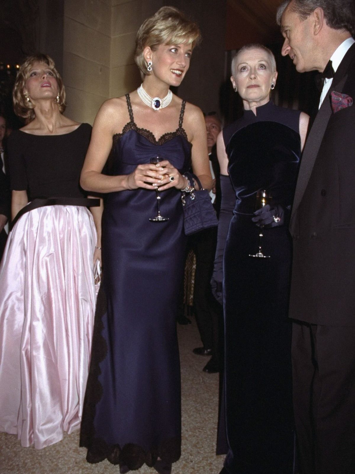 Met Gala Outfits 2026: 10 Looks That Stole the Night 9 Princess Diana wearing a navy blue satin gown and sapphire necklace at a gala.