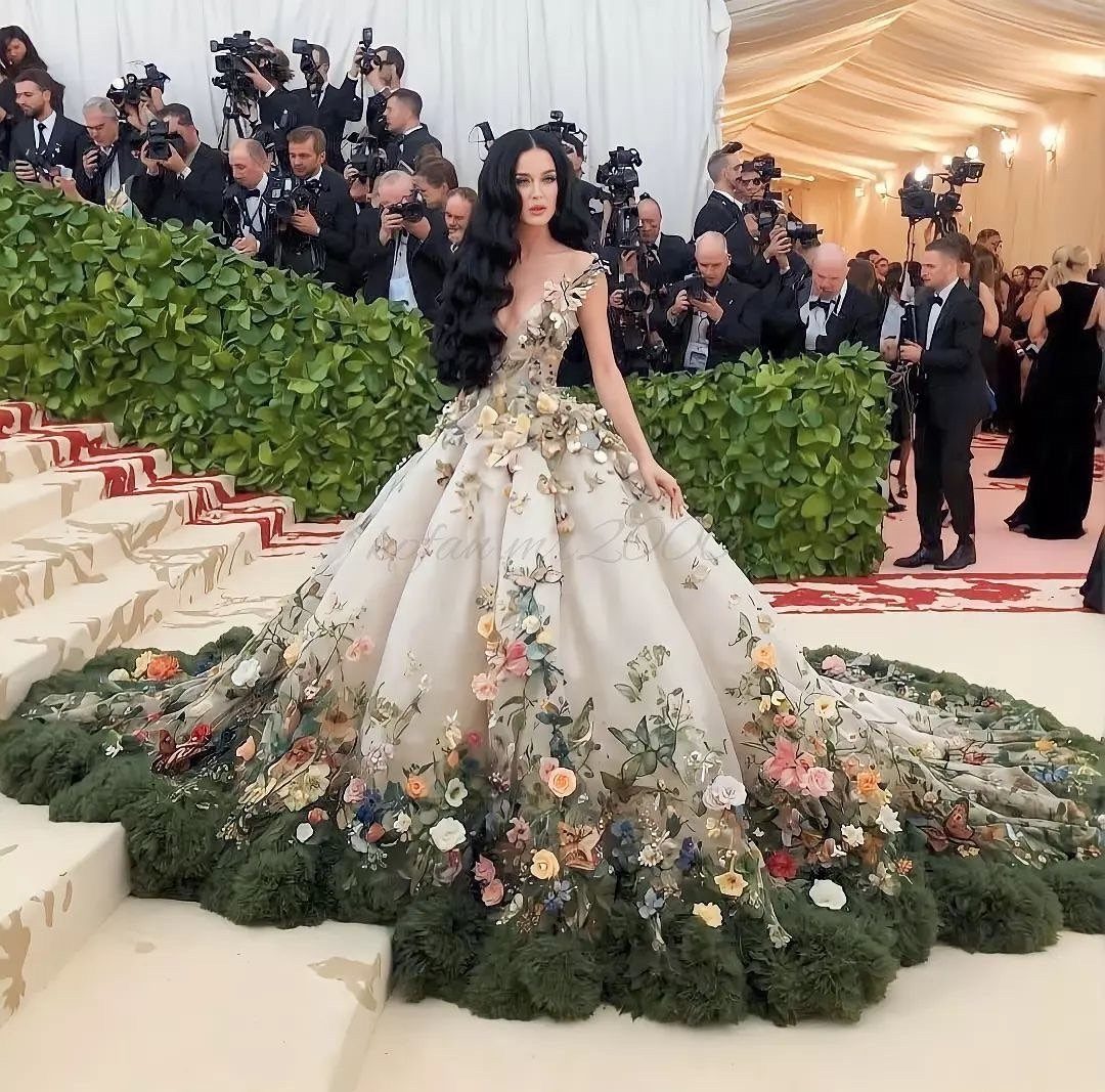 Met Gala Outfits 2026: 10 Looks That Stole the Night 7 Woman in a voluminous cream floral ball gown posing on a white staircase.