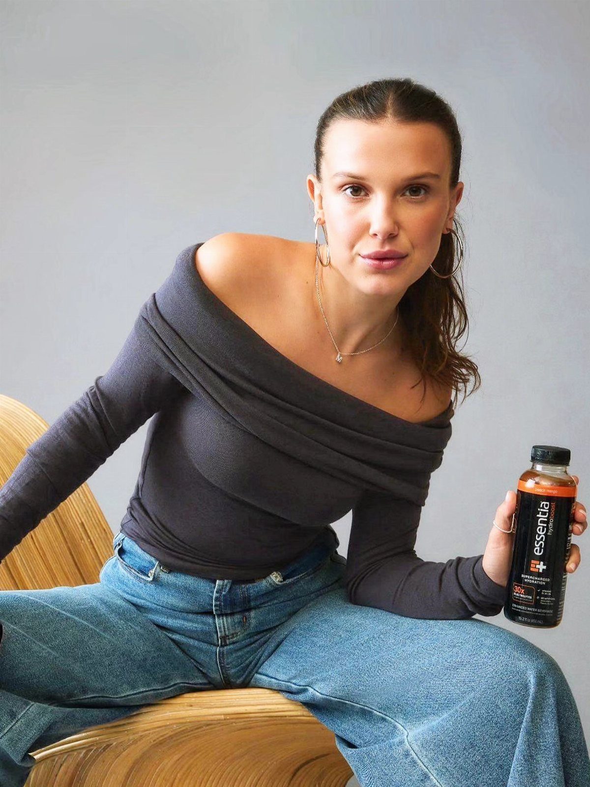 15 Millie Bobby Brown Outfits to Inspire Your Wardrobe 15 Millie Bobby Brown in a grey off-the-shoulder top and blue wide-leg jeans.