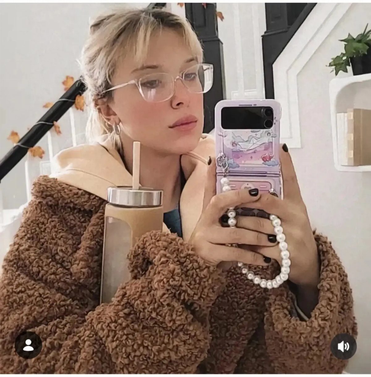 15 Millie Bobby Brown Outfits to Inspire Your Wardrobe 9 Young woman wearing a brown teddy fleece coat and tan hoodie for winter.