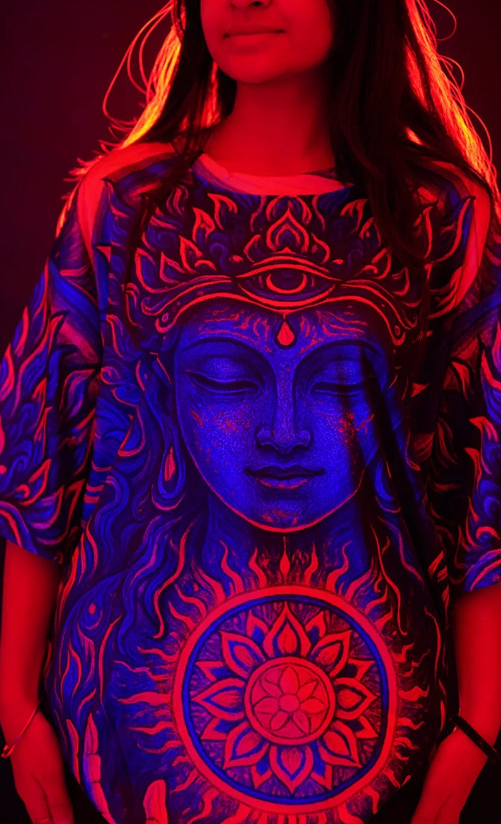 3 Modest Rave Outfits That Keep You Covered and Comfortable 2 Person wearing an oversized neon psychedelic t-shirt with a glowing blue face design.