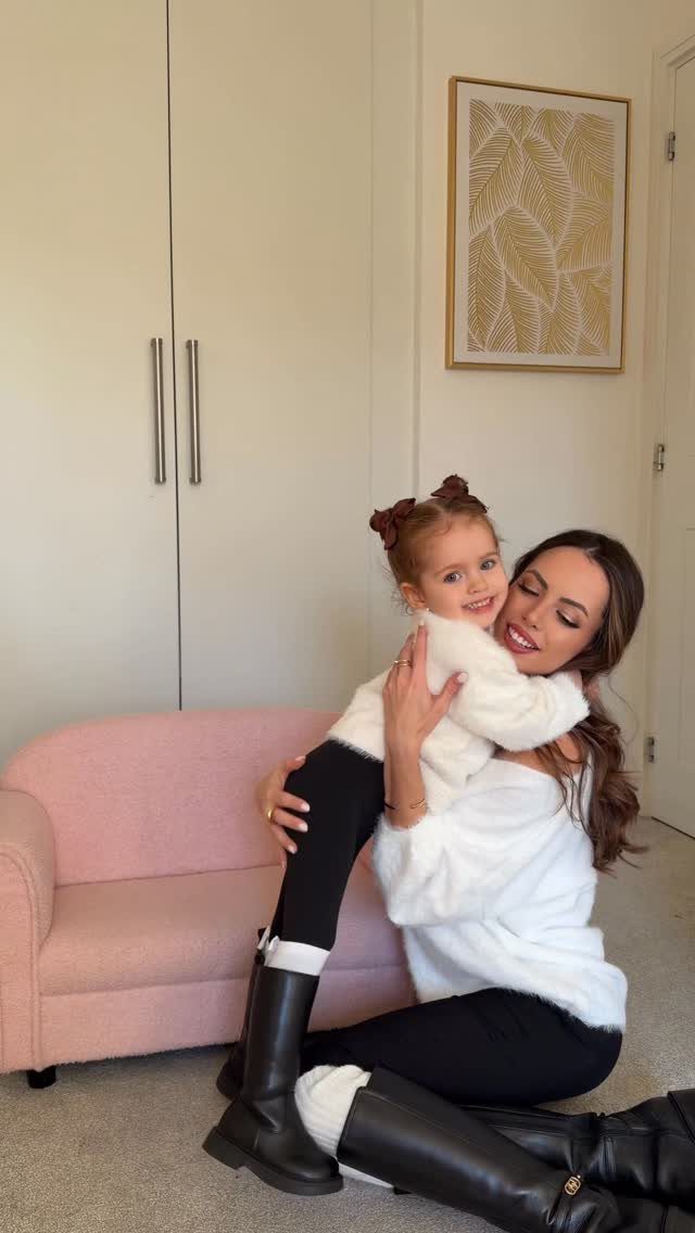 Mom and Daughter Matching Outfits for Every Occasion (6) 5 Woman and young daughter hugging in matching white fluffy sweaters and black leggings.