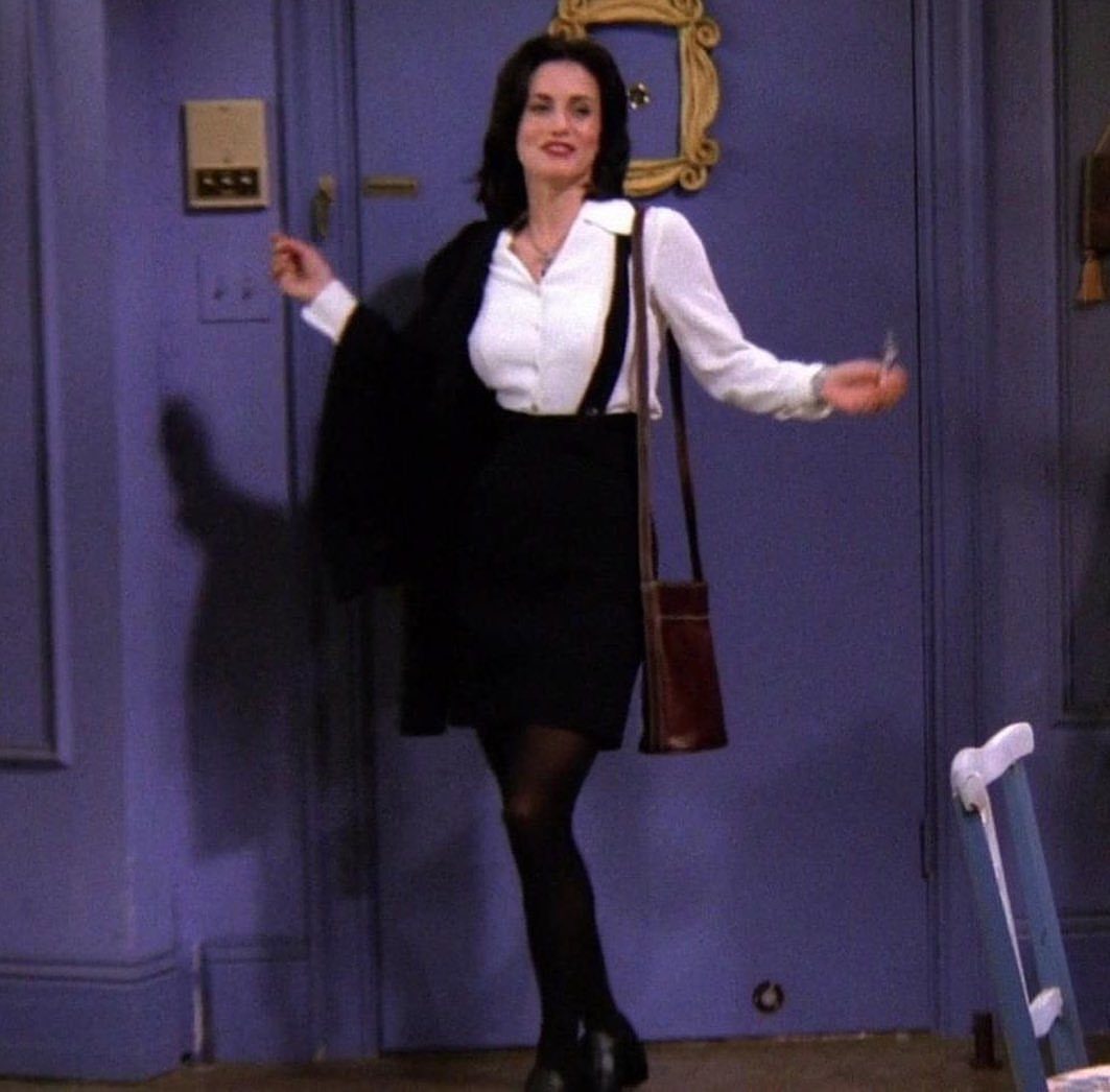 Monica Geller Outfits: 8 Iconic Looks to Recreate Now 2 Woman wearing a white button-up shirt with a black skirt and blazer.