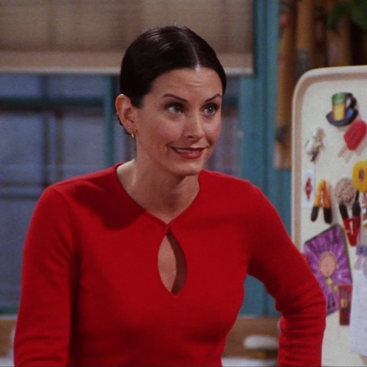 Monica Geller Outfits: 8 Iconic Looks to Recreate Now 8 Woman wearing a bright red long-sleeved top with a keyhole neckline.