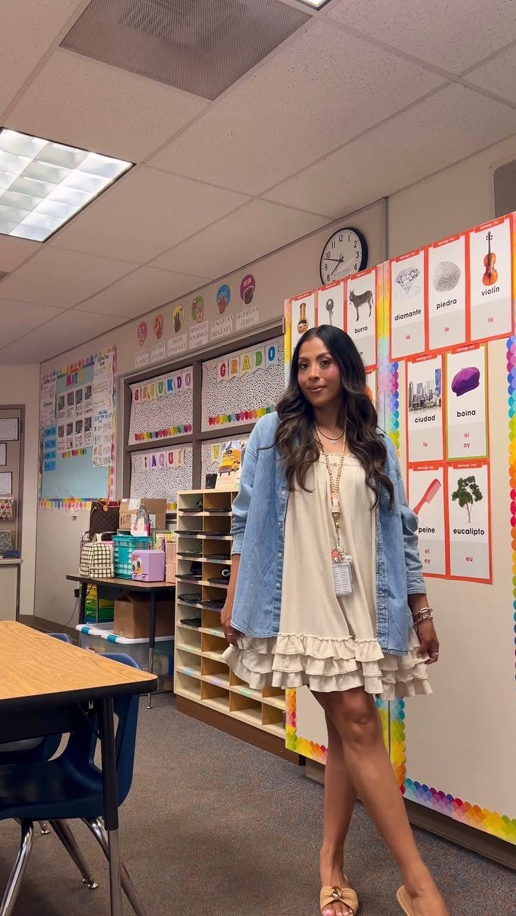 Picture Day Outfits That Photograph Beautifully (7 Ideas) 3 Woman in a beige ruffled dress and denim jacket posing in a classroom.